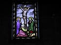 Christ en croix entouré de trois personnages - vitrail de cimetière - © Norbert Pousseur