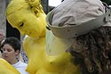 Comédienne jaune statufiée et transportée par aide barbu - © Norbert Pousseur