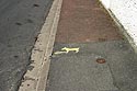 Logo sur trottoir pour que les chiens fassent dans le caniveau, Graph’mur photographié par Norbert Pousseur ©