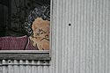 Personnage surveillant du coin de sa fenêtre, Graph’mur photographié par Norbert Pousseur ©