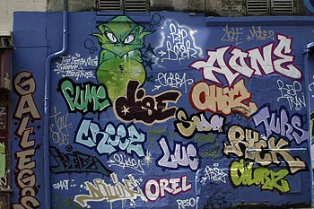Signatures taguées autour d'un monstre vert, Graph’mur photographié par Norbert Pousseur ©
