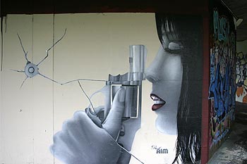 Jeune femme au pistolet - signé Disk AIM, Graph’mur photographié par Norbert Pousseur ©
