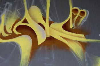 Signature graphique jaune sur fond gris - graphmur de Baden photographié par Norbert Pousseur ©