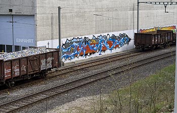 Fresque sur mur de béton entre deux wagons - graphmur photographié par Norbert Pousseur ©