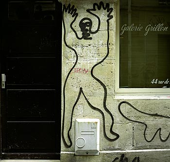 Grand corps tracé devant une porte d'entrée de galerie, Graph’mur photographié par Norbert Pousseur ©