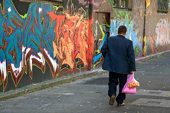 Homme de retour de courses devant un mur de tags - Bagnolet 2009, photographié par Norbert Pousseur ©