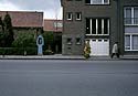 rue vide, oratoire, et passant déguisé en chat - Kattenstoet 1977 - fête des chats - Ieper - Ypres - © Norbert Pousseur
