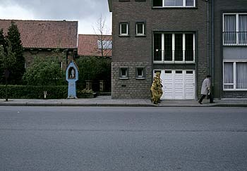 rue vide, oratoire, et passant déguisé en chat - Kattenstoet 1977 - fête des chats - Ieper - Ypres - © Norbert Pousseur