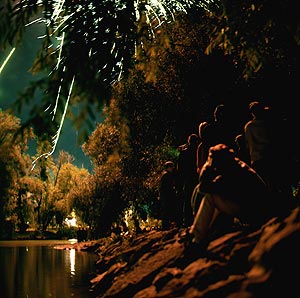 Groupe assis sur la rive et contemplant le feu d'artifice de Gournay - © Norbert Pousseur