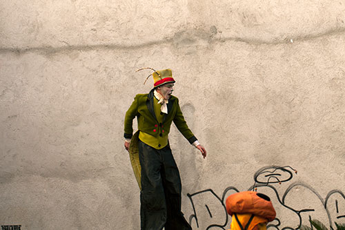 Man in stilts evolving in front of a wall - © Norbert Pousseur