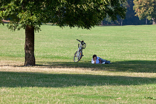 Lecteur à vélo, allongé sur la pelouse d'un parc - © Norbert Pousseur