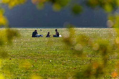 Couple avec enfant assis sur l'herbe d'un parc - © Norbert Pousseur