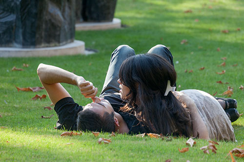 Jeune couple d'amoureux allongé sur la pelouse d'un parc - © Norbert Pousseur