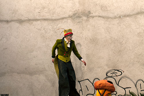 Homme aux échasses évoluant devant un mur - © Norbert Pousseur