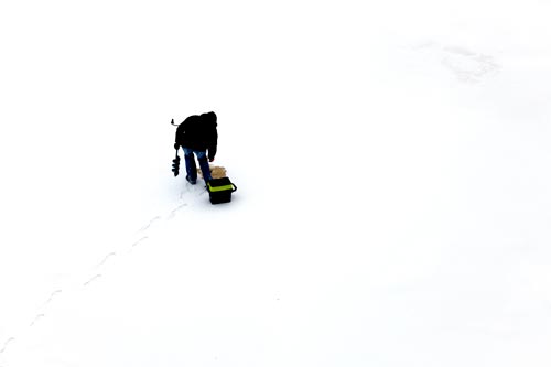 Pêcheur inspectant un de ses trous de pêche - © Norbert Pousseur