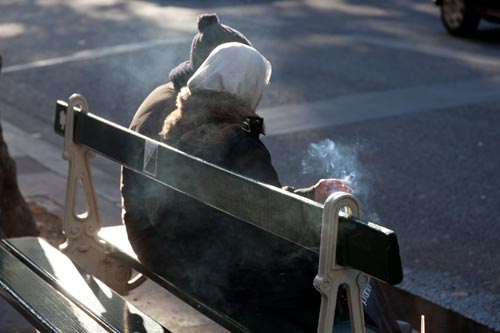 Homeless smoking on bench - © Norbert Pousseur