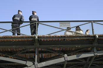 Policiers en observation appuyés sur une balustrade de pont - © Norbert Pousseur