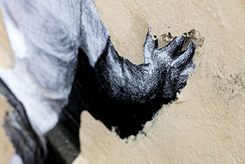 Main se déchirtant sur un mur -  © Norbert Pousseur
